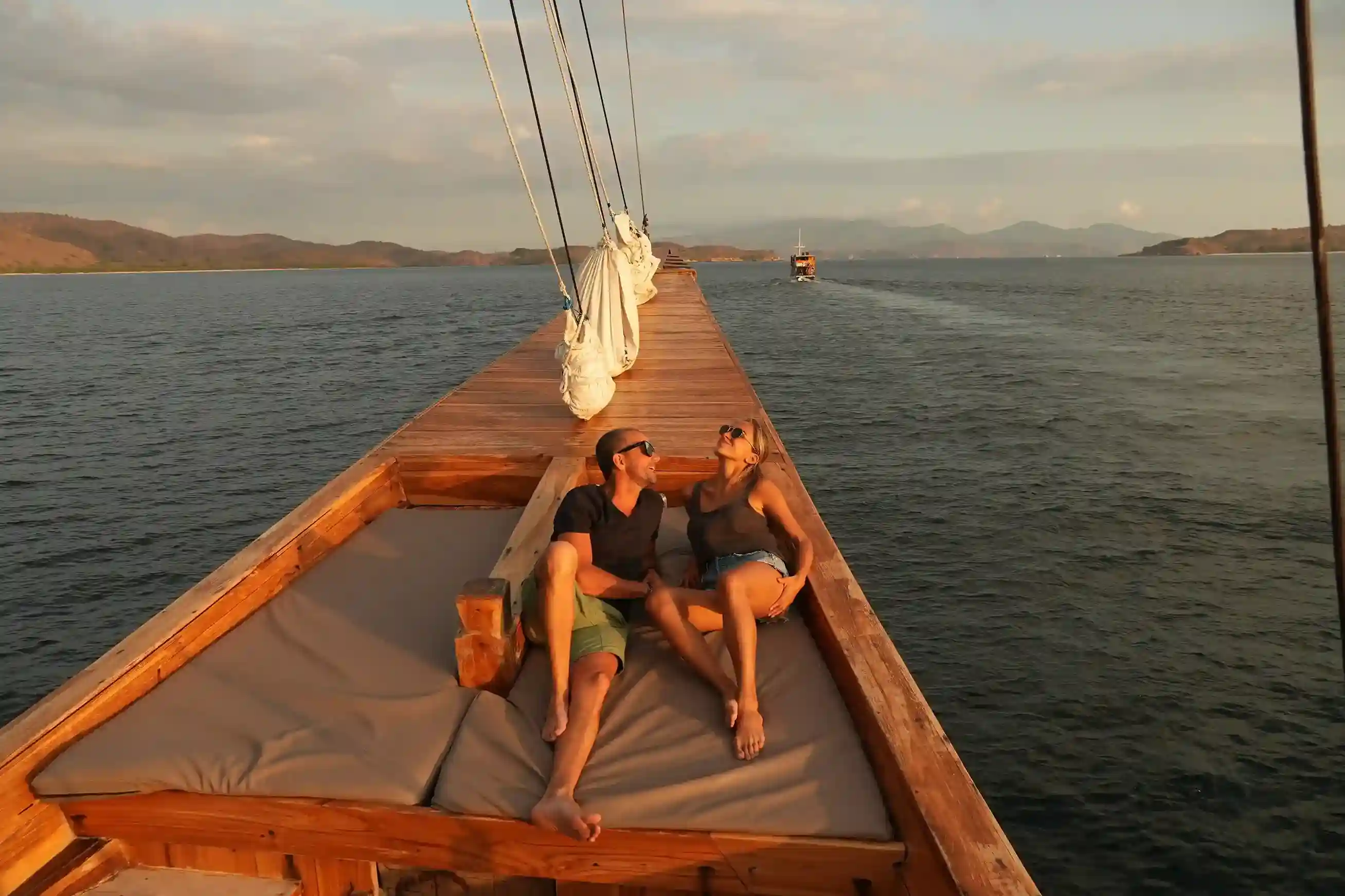 Guests on the bow of a phinisi under sail